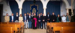 Una veintena de personas de pie entre los bancos del Oratorio de la Purísima, ante el altar con el escudo